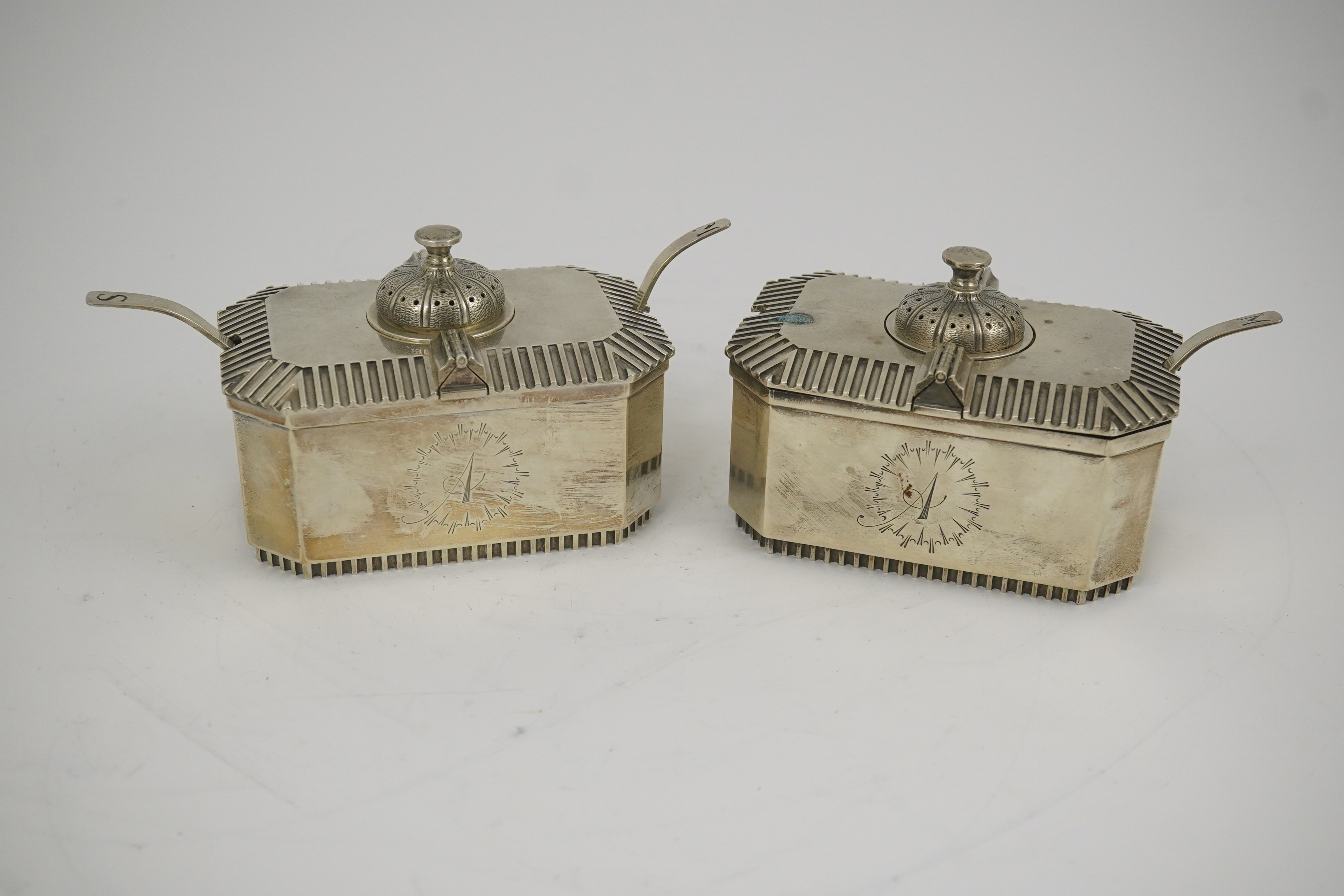 A pair of Elizabeth II silver double lidded condiments and matching spoons, by Hennell, Frazer & Haws